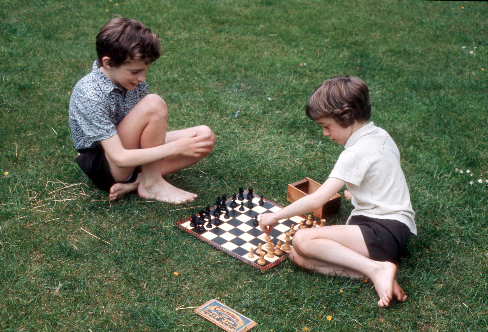 7303620k May 1973 - The boys playing chess in the garden at Croydon.