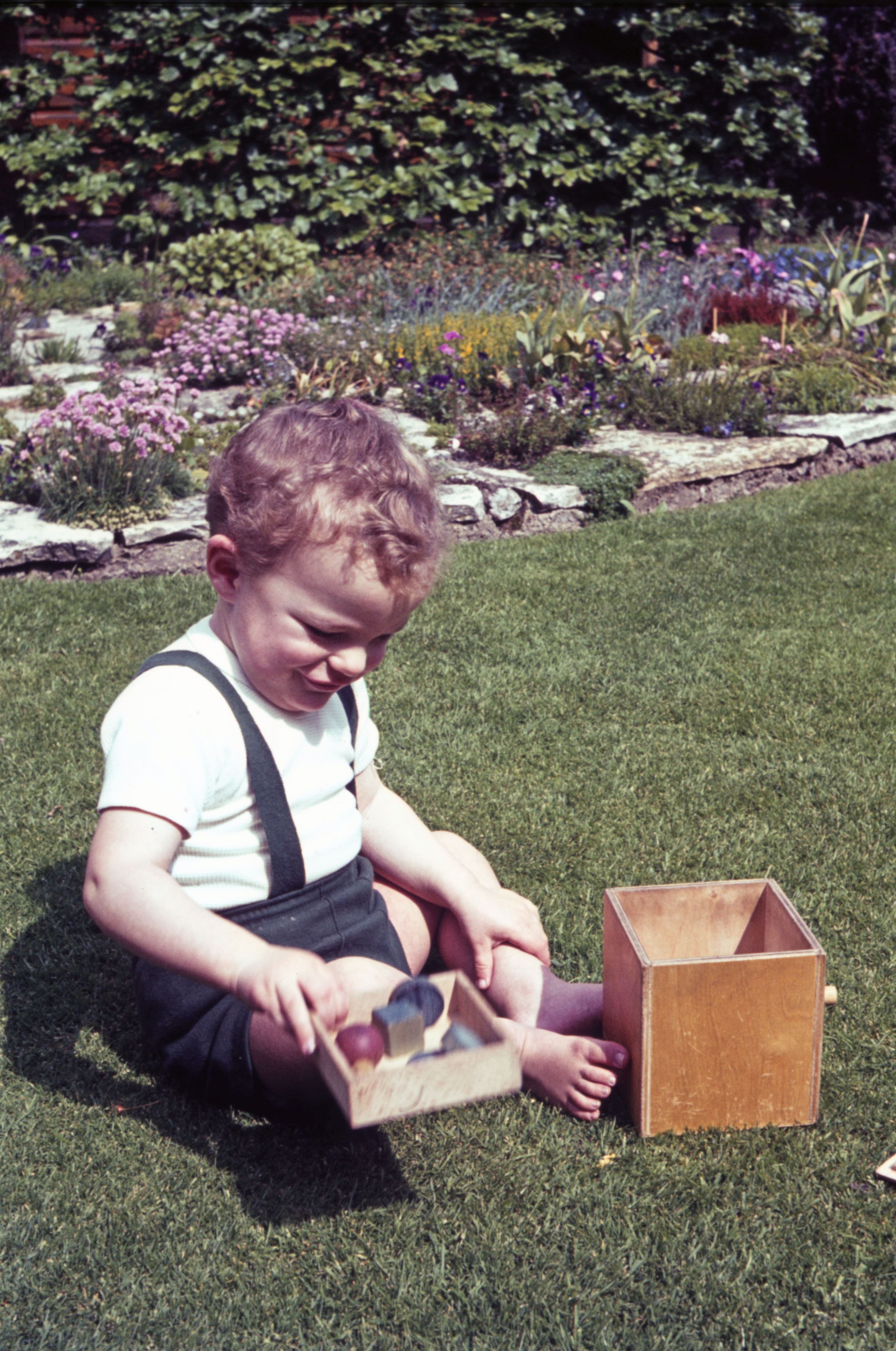 May 1965 Simon is playing with a shapes puzzle.