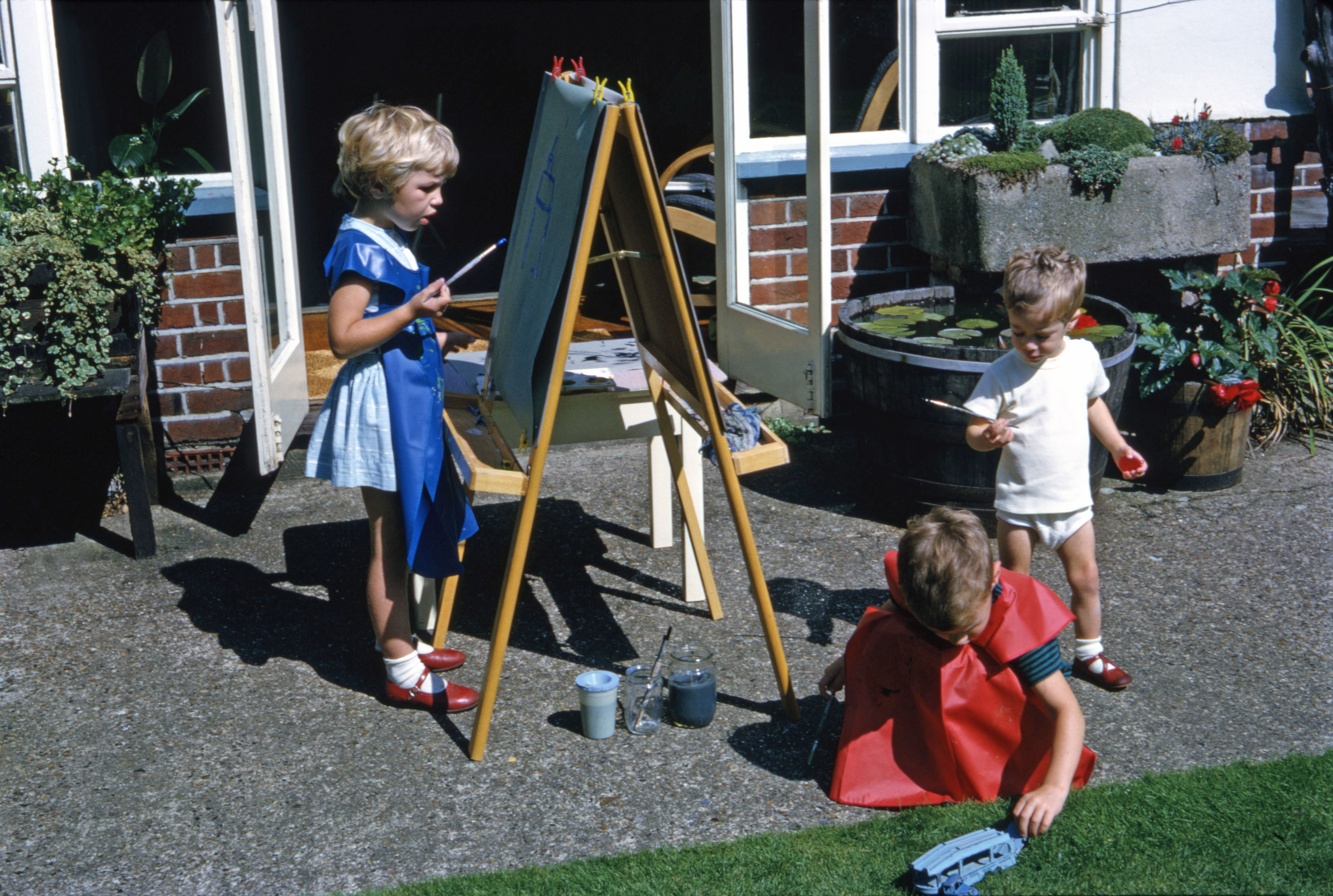 Summer 1967 Painting at easel. Nicola, Simon and Jonathan at Hampton.