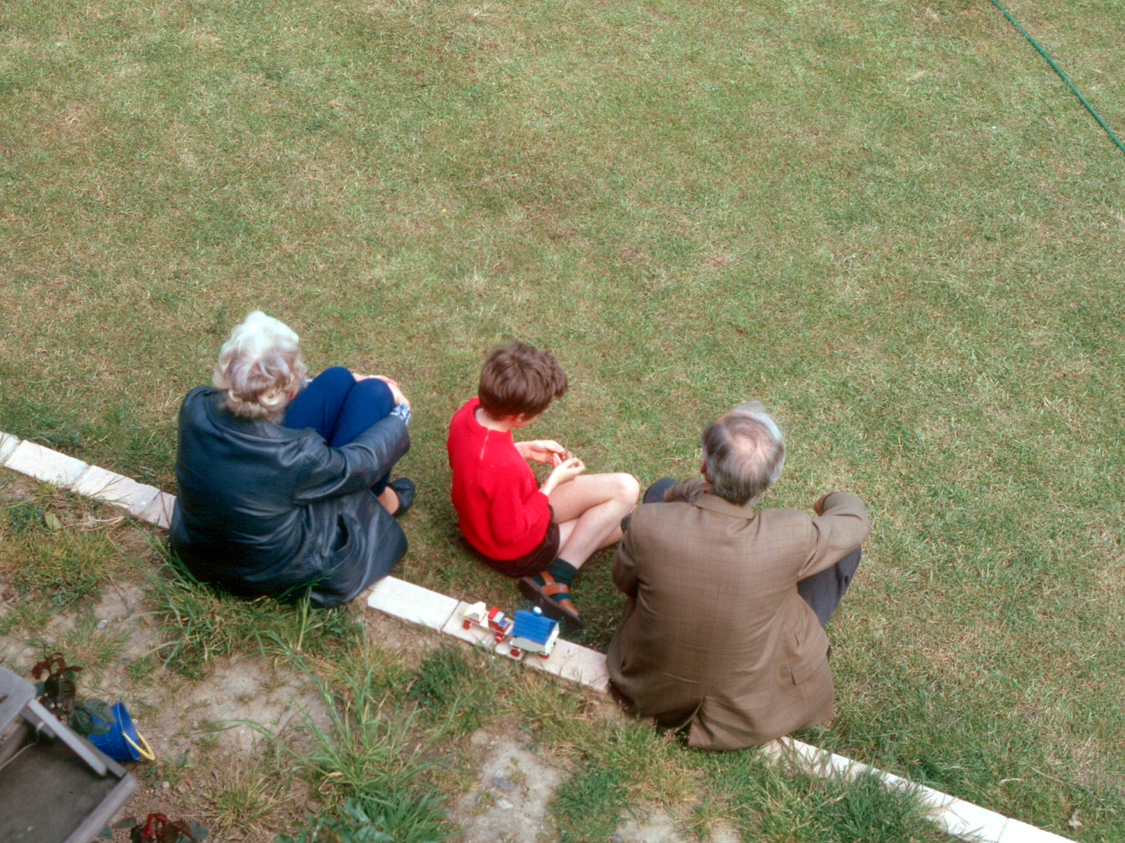 7203108k May 1972 - Mum, Dad and Simon sitting on the edge of the garden path in Croydon